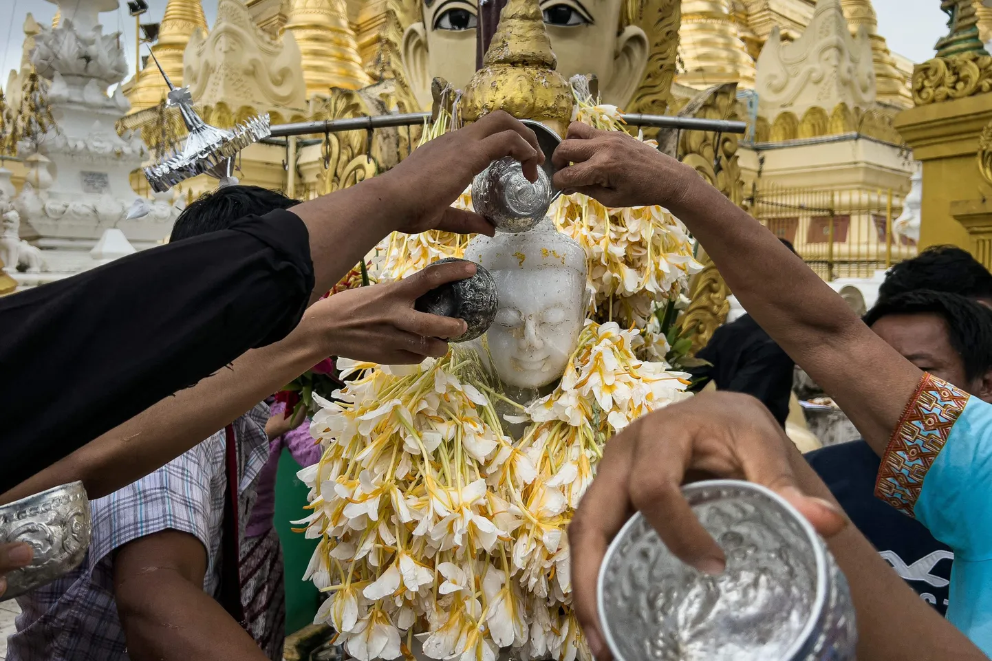 Kummardajad kallavad vett Buddha kujule. 20. juuli 2024, Yangon, Myanmar.