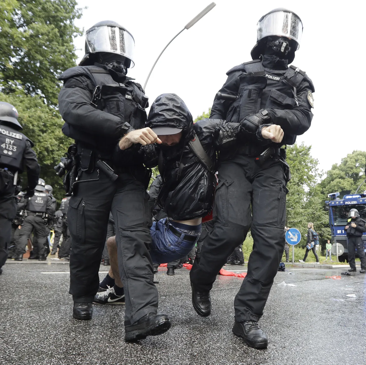 Politseinikud meeleavaldajat transportimas.