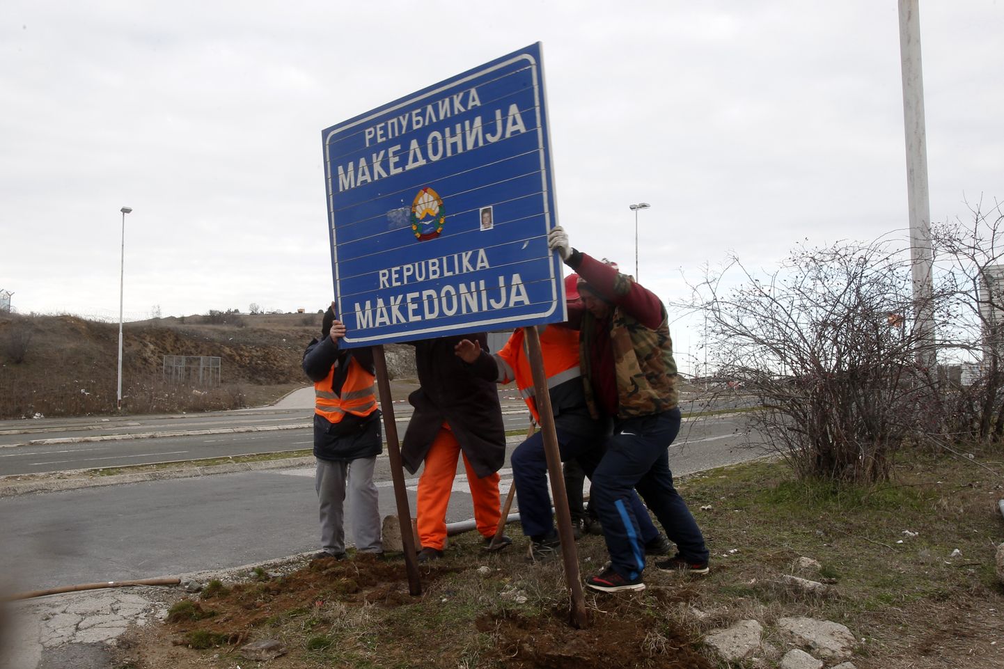 Töölised eemaldamas Põhja-Makedoonia vana nimega teesilti.