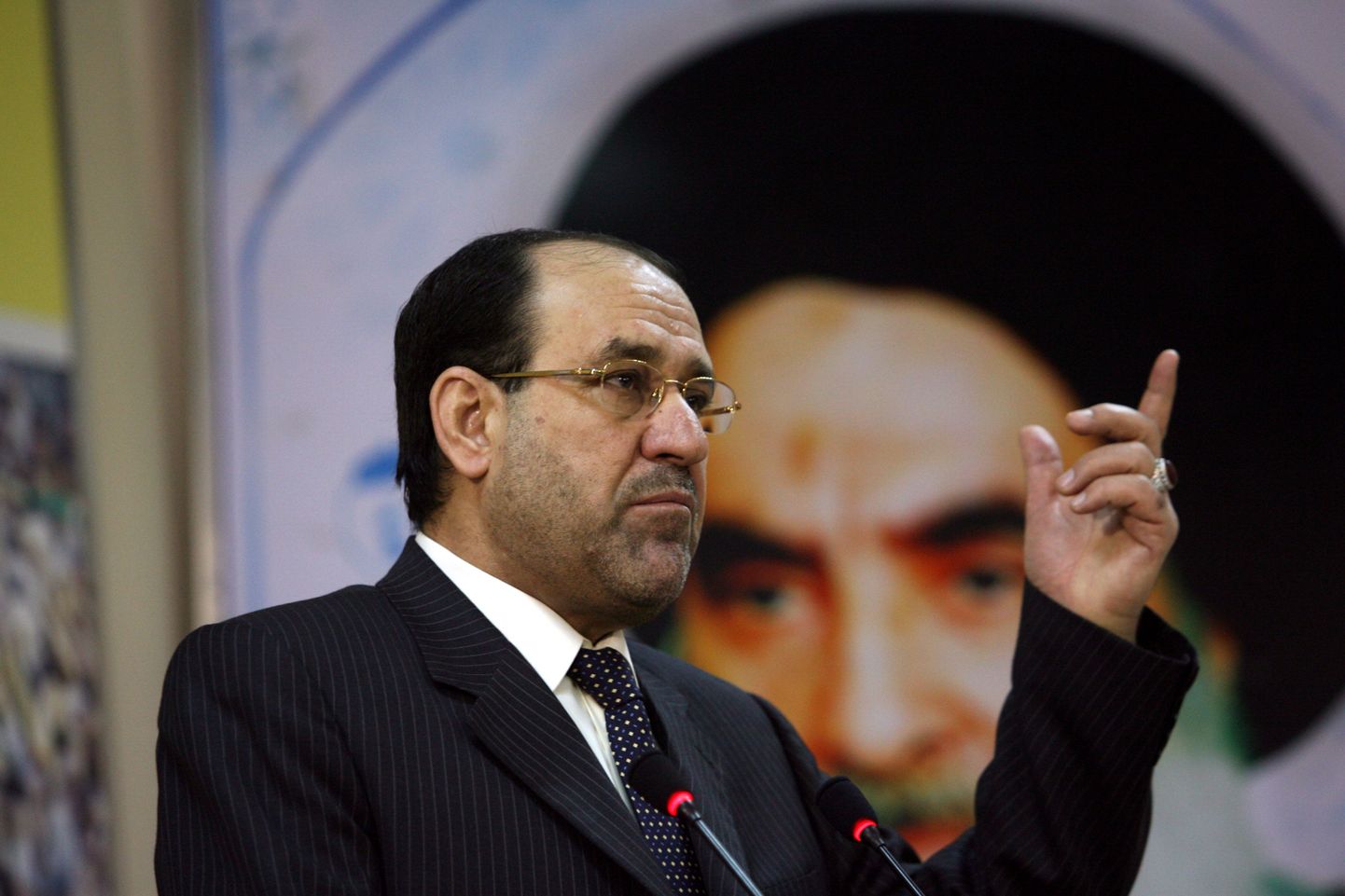 Iraagi peaminister Nuri al-Malik, taustal riigi tähtsaima šiiavaimuliku suurajatolla Ali al-Sistani portree.