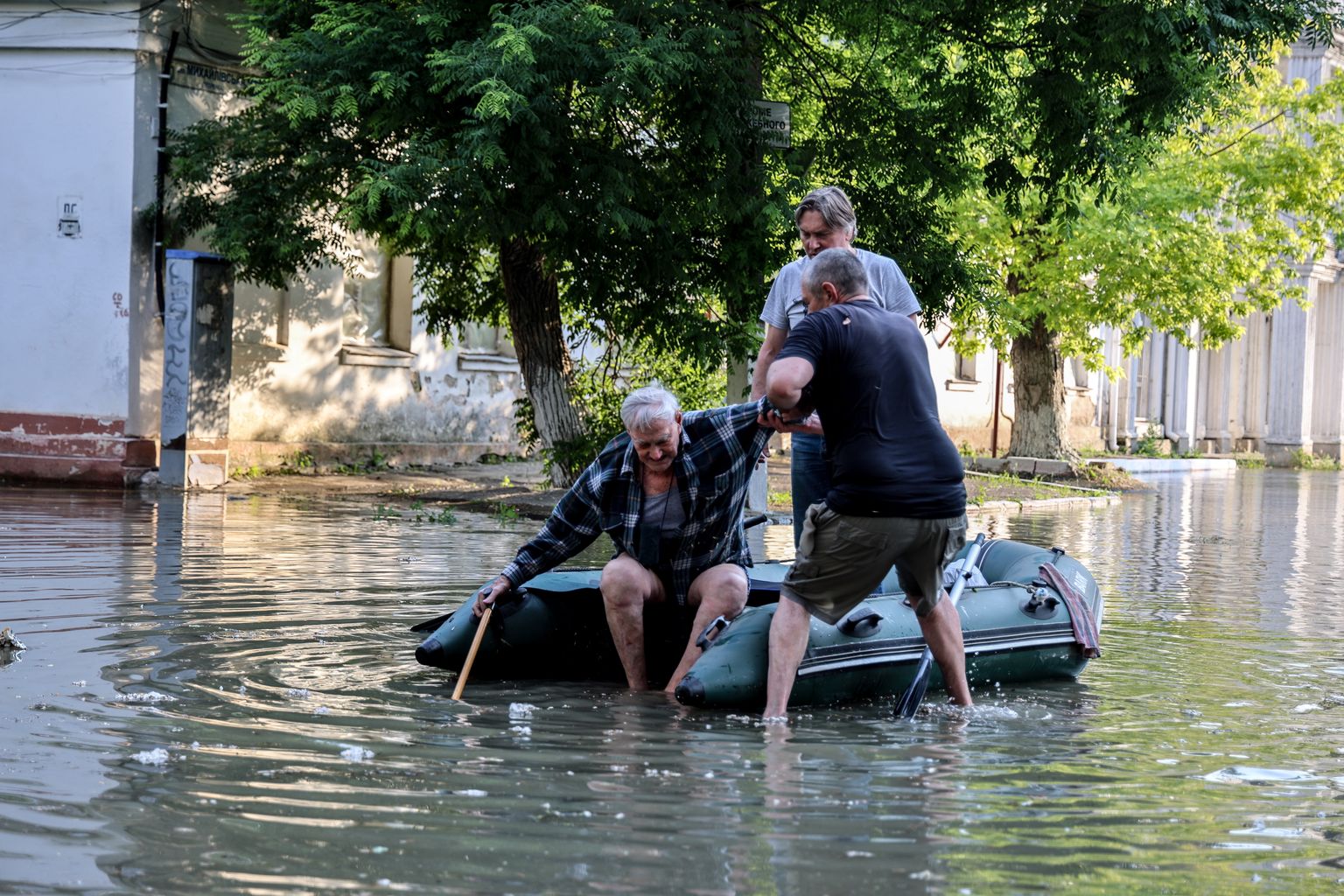 Hersoni elanikud aitavad eakat meest kummipaadile, et teda üleujutatud tänaval asuvast kodust evakueerida.