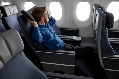 Mees Finnairi uues Premium Economy salongis kaelapatja kasutamas.