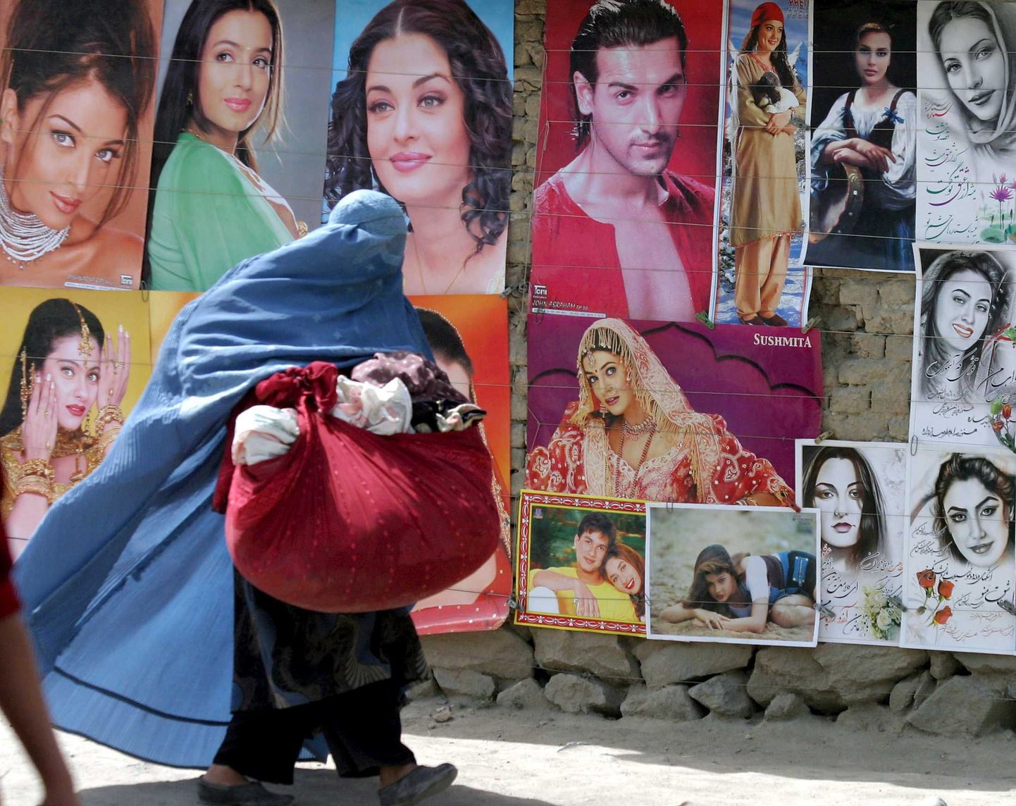 Afgaani naine möödumas Bollywoodi näitlejate plakatitest.