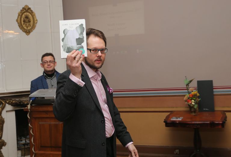 Vahur Afanasjev näitas saali täitnud kirjandushuvilistele preemia saanud Madli Lippuri romaani. Tagaplaanil Eesti kirjanike liidu Tartu osakonna esimees Berk Vaher.