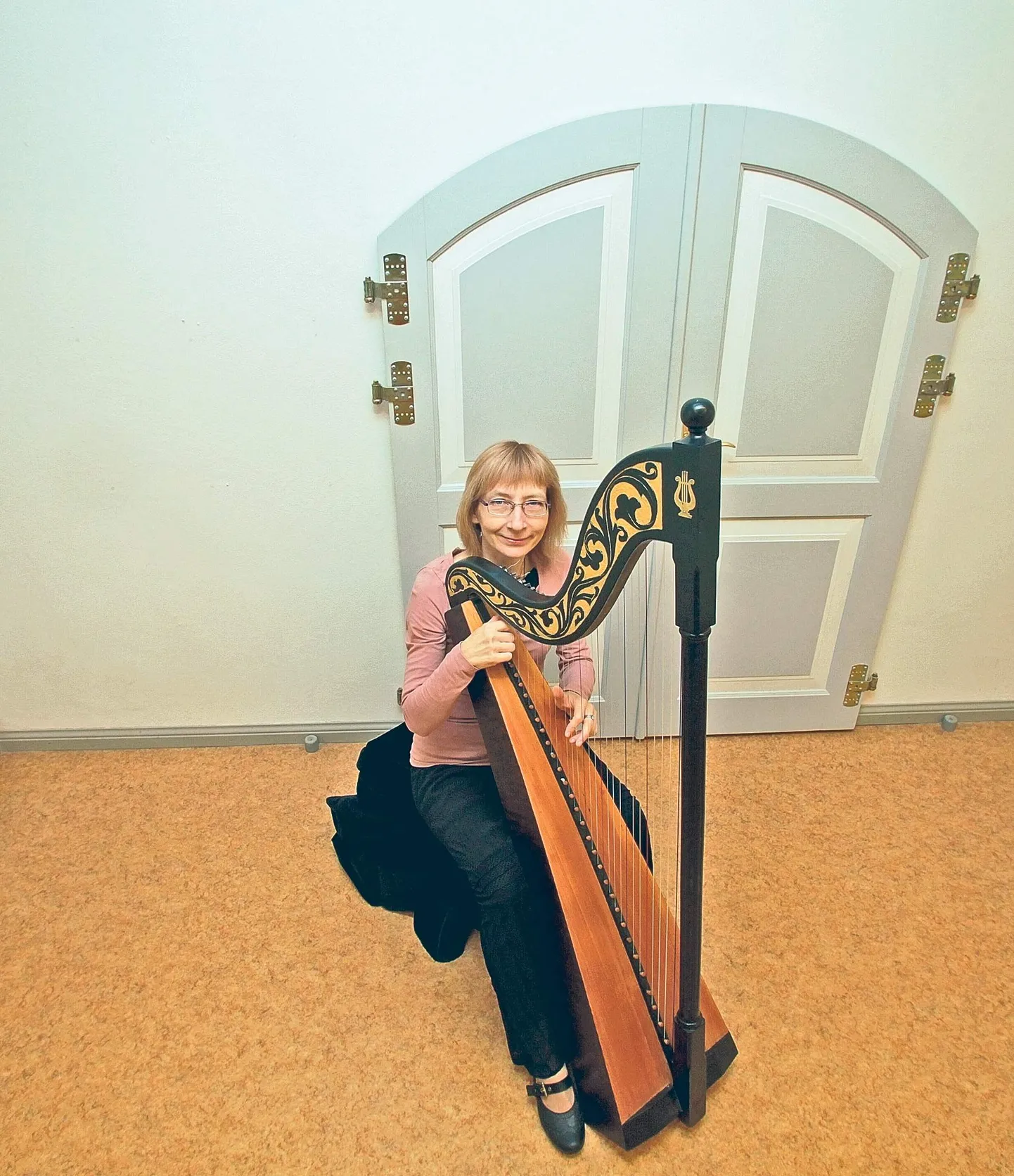 Lilian Langsepp tutvustas restaureeritud harfi reporterile ülikooli peahoones.