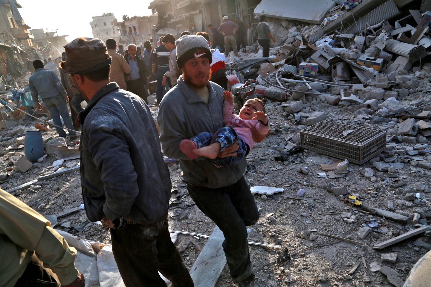 Süüria mees kandmas last pärast Atarebi turul korraldatud Venemaa õhurünnakut.