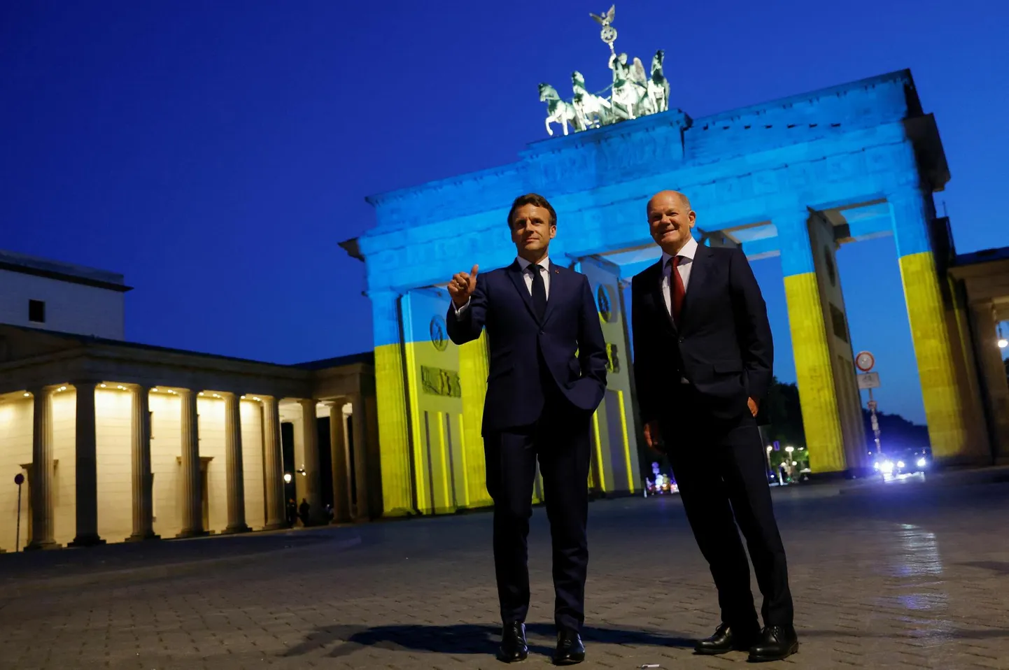 Saksamaa kantsler Olaf Scholz ja Prantsusmaa president Emmanuel Macron poseerimas Ukraina lipu värvides Brandenburgi värava ees Berliinis. Kriitikute sõnul on tegemist kehva asendusega Ukrainasse sõitmisele.