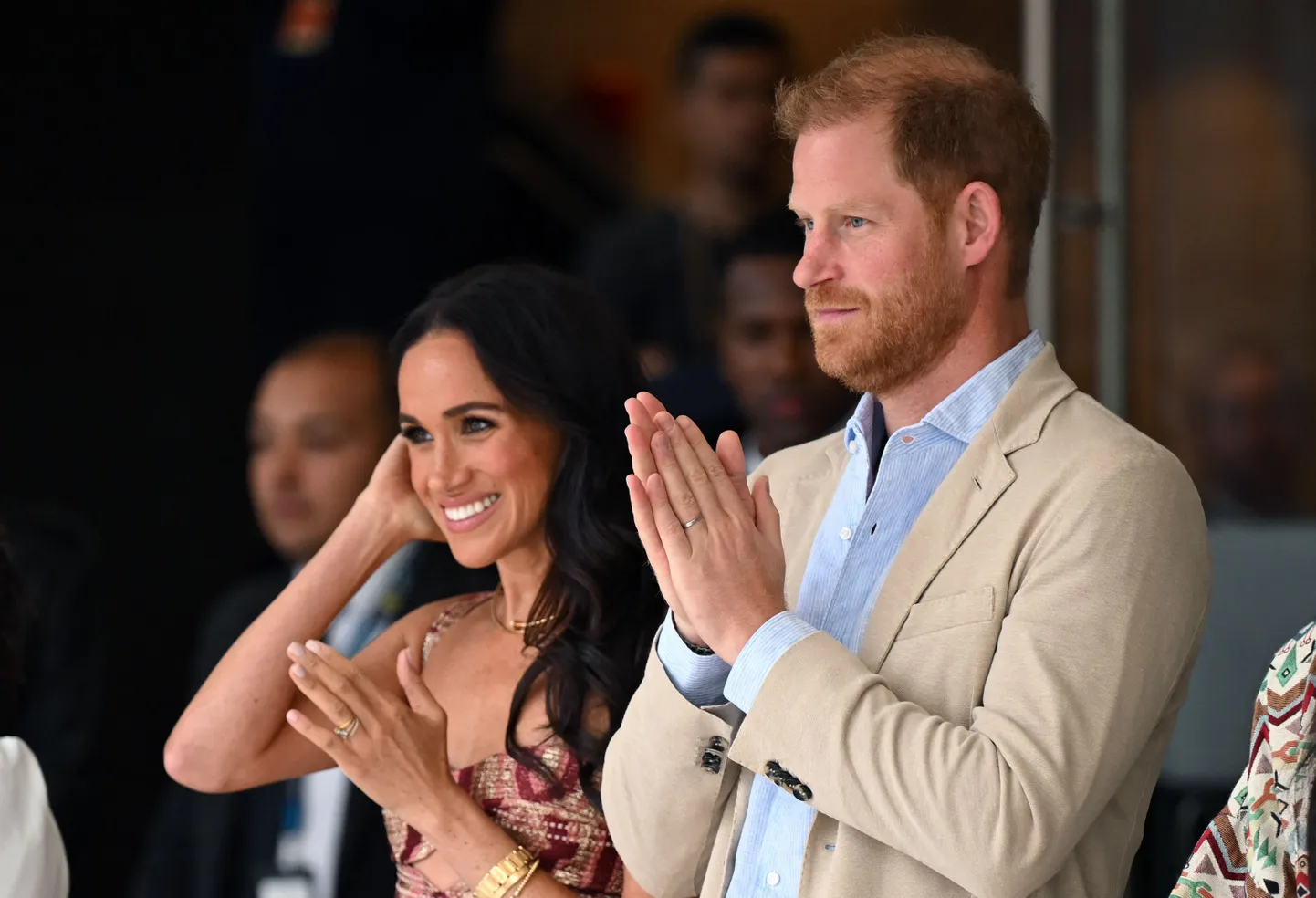Britain's Prince Harry (C), Duke of Sussex, and his wife Meghan Markle react while attending a show during a visit to the National Centre for the Arts in Bogota on August 15, 2024. Prince Harry and his wife, American actress Meghan Markle, arrived in Colombia at the invitation of Marquez, with whom they will attend various meetings with women and young people to reject discrimination and cyberbullying. (Photo by RAUL ARBOLEDA / AFP)