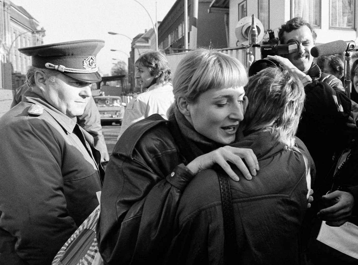 Idaberliinlane(keskel) kallistamas pärast piiriületust lääneberliinlast. Seda vaatab pealt DDRi piirivalveohvitser ning jäädvustab meedia