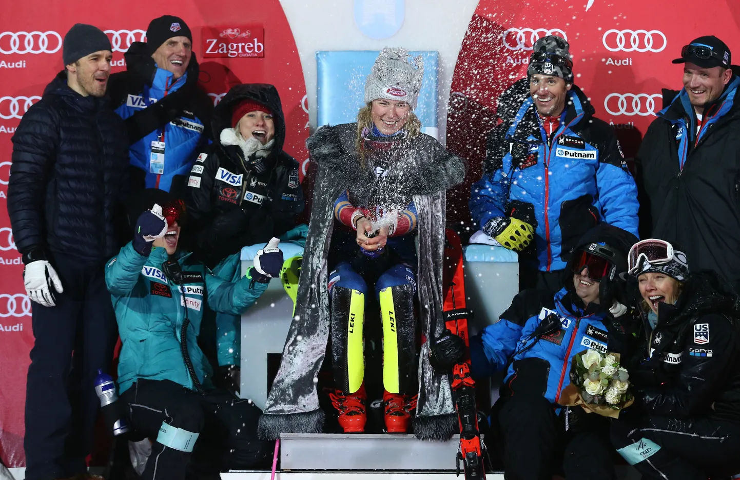 Uhke võitjakrooniga Mikaela Shiffrin koos oma tiimi liikmetega pärast järjekordset esikohta.