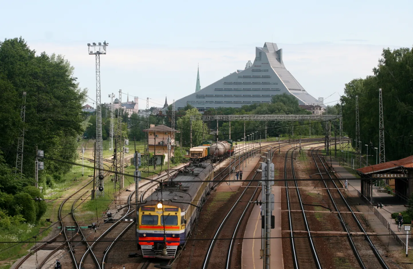Vilciens pie Torņkalna stacijas un Latvijas Nacionālās bibliotēkas ēka.
