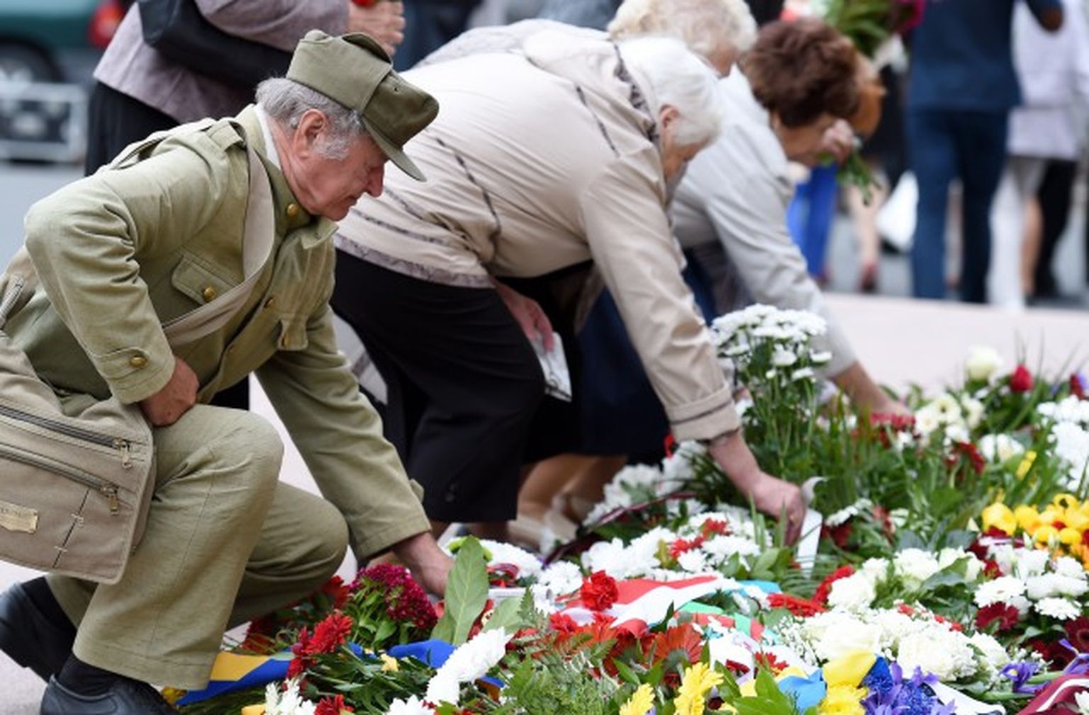 Cilvēki noliek ziedus pie Brīvības pieminekļa komunistiskā genocīda upuru pimiņai