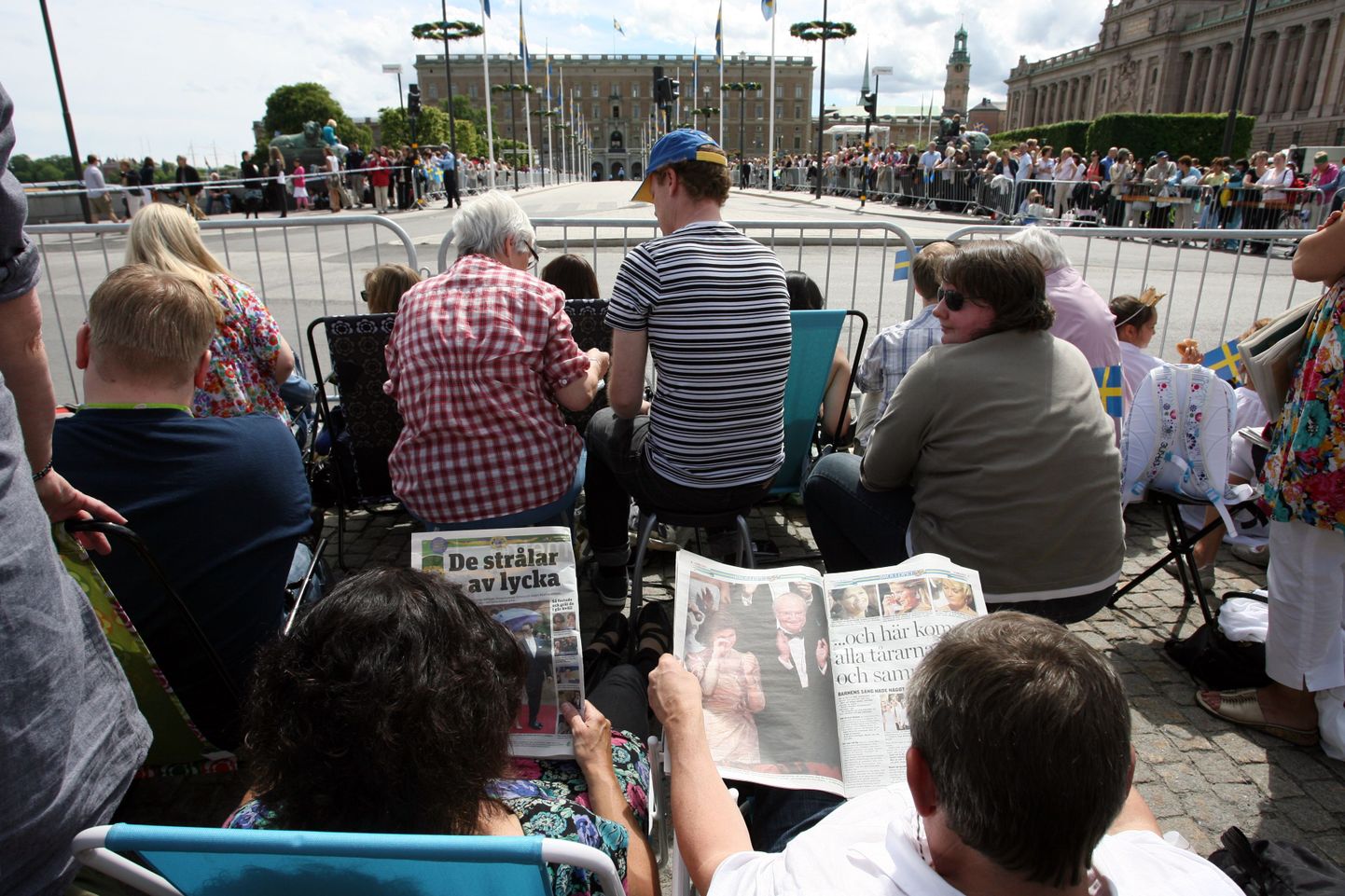 Pilt mullusest Stockholmist, kui inimesed lugesid kroonprintsess Victoria ja Daniel Westlingi pulmadefileed oodates kohalikke ajalehti