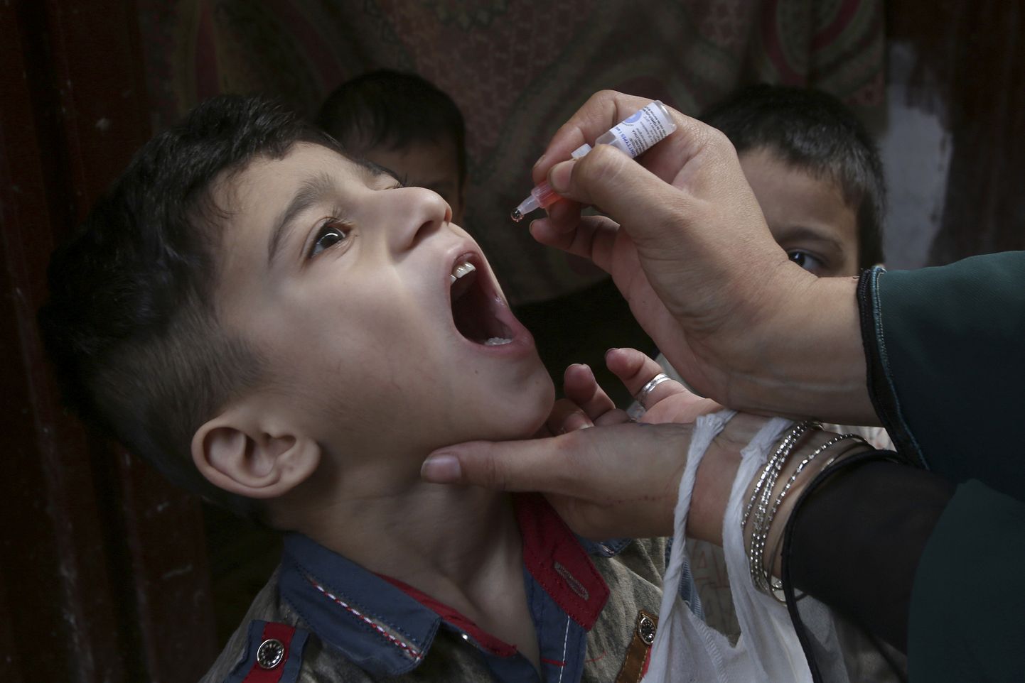 Bērns Pakistānā saņem perorālo vakcīnu pret bērnu trieku.