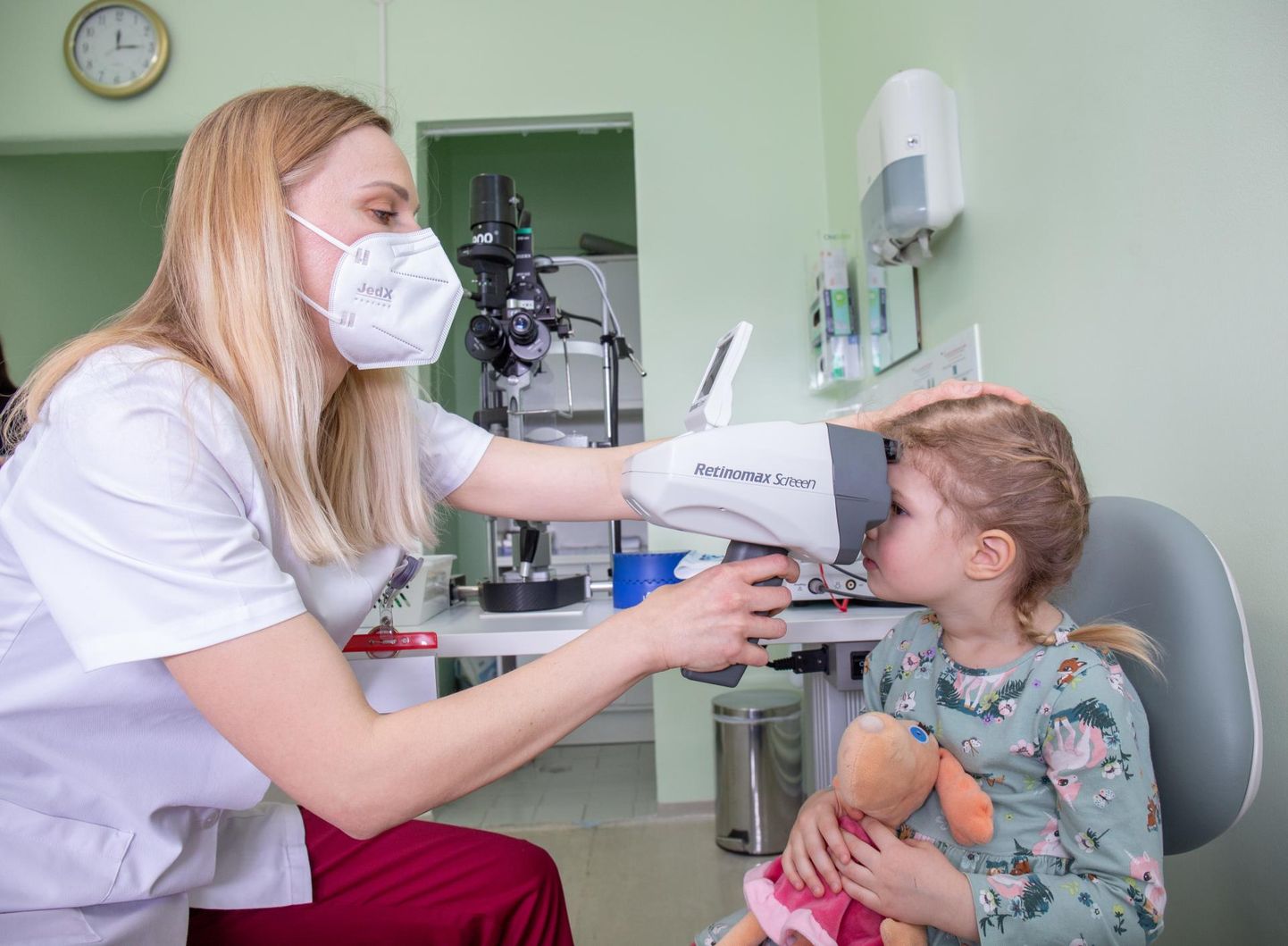 Viljandi haigla silmaarst Anne-Liis Matson kontrollib lapse silma ehitust käsiautorefraktomeetriga.