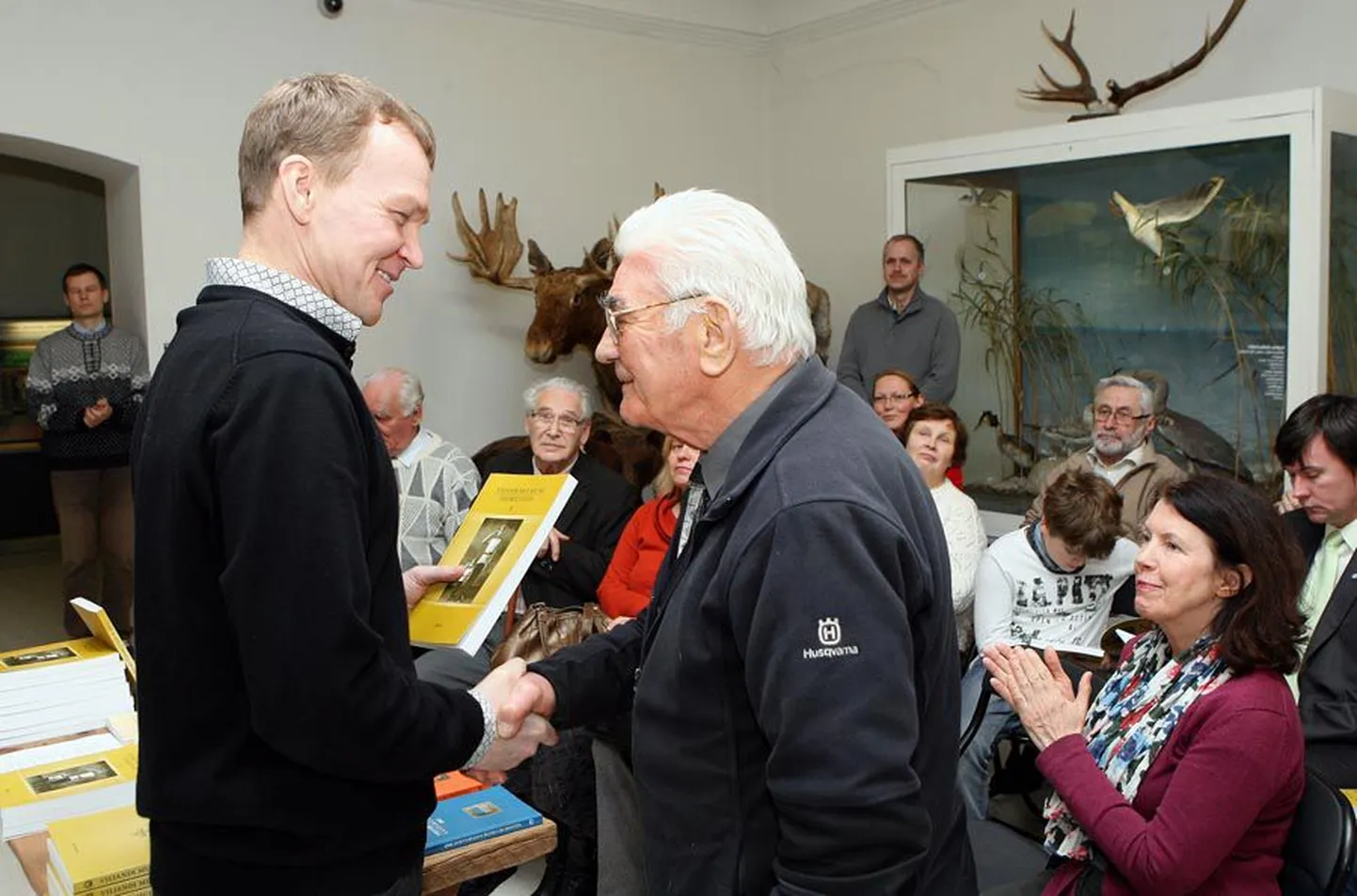 Muuseumi direktor Jaak Pihlak (vasakul) annab toimetiste kaas­autorile Karl Luhtile trükisooja raamatu.