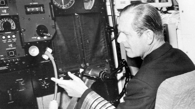 Герцог Эдинбургский в форме адмирала флота сидит за штурвалом атомной подводной лодки HMS Churchill