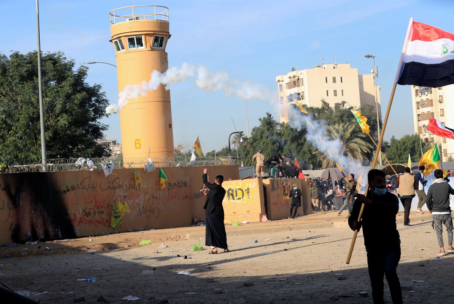 Protestijad ja relvarühmituste võitlejad viskamas 1. jaanuaril tagasi gaasikanistrit Bagdadis asuva USA saatkonna suunas.