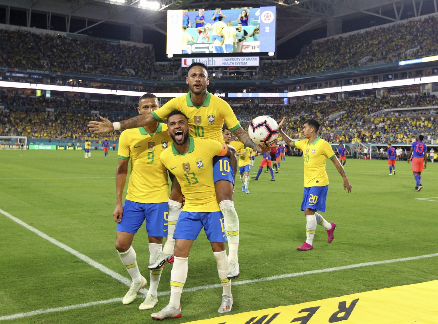 Brazil forward Neymar (10) celebrates with Dani Alves (13) and Richarlison (9) after scoring the second goal of his team during the second half of an international friendly soccer match against Colombia, Friday, Sept. 6, 2019, in Miami Gardens, Fla. (David Santiago/Miami Herald via AP)