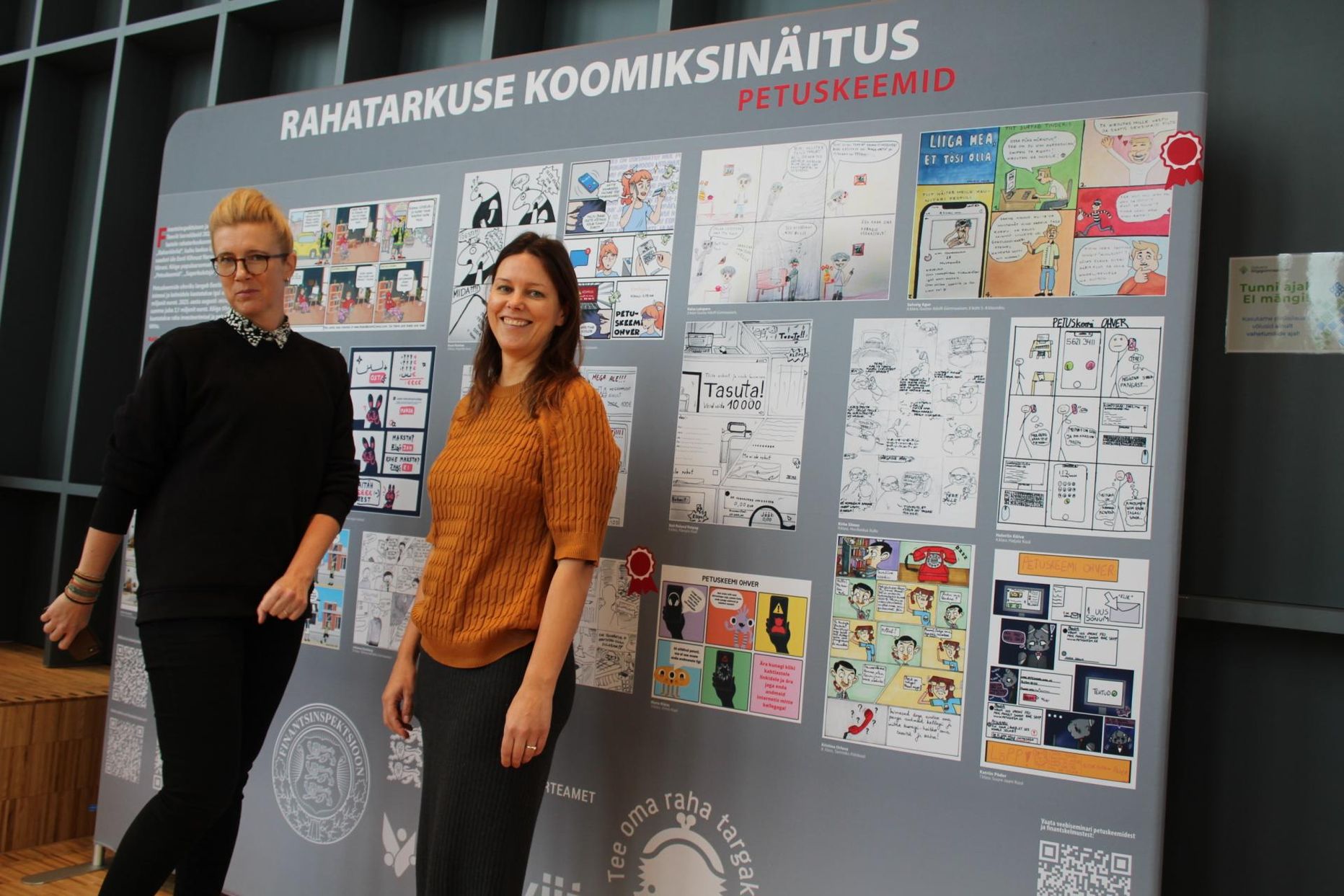 Kaisa Gabral ja Eva Vahur Rakvere riigigümnaasiumis koomiksinäituse ees.