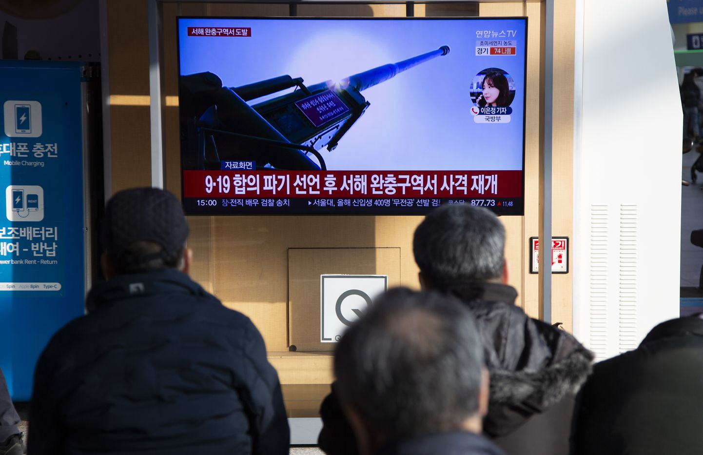 Корейцы наблюдают за происходящем по телевизору.