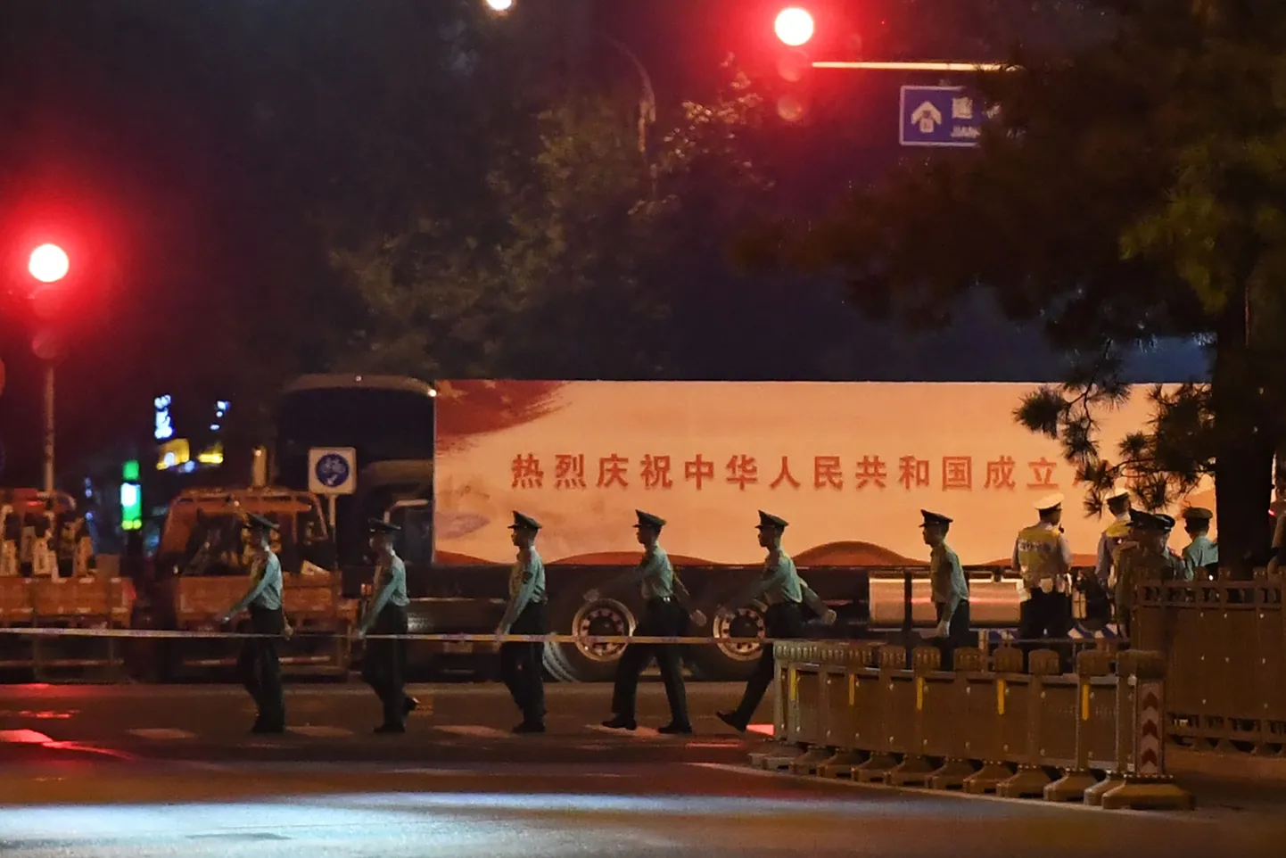 Propagandaloosungiga veok suundumas sõjaväeparaadi proovi Pekingi Tiananmeni väljakul.