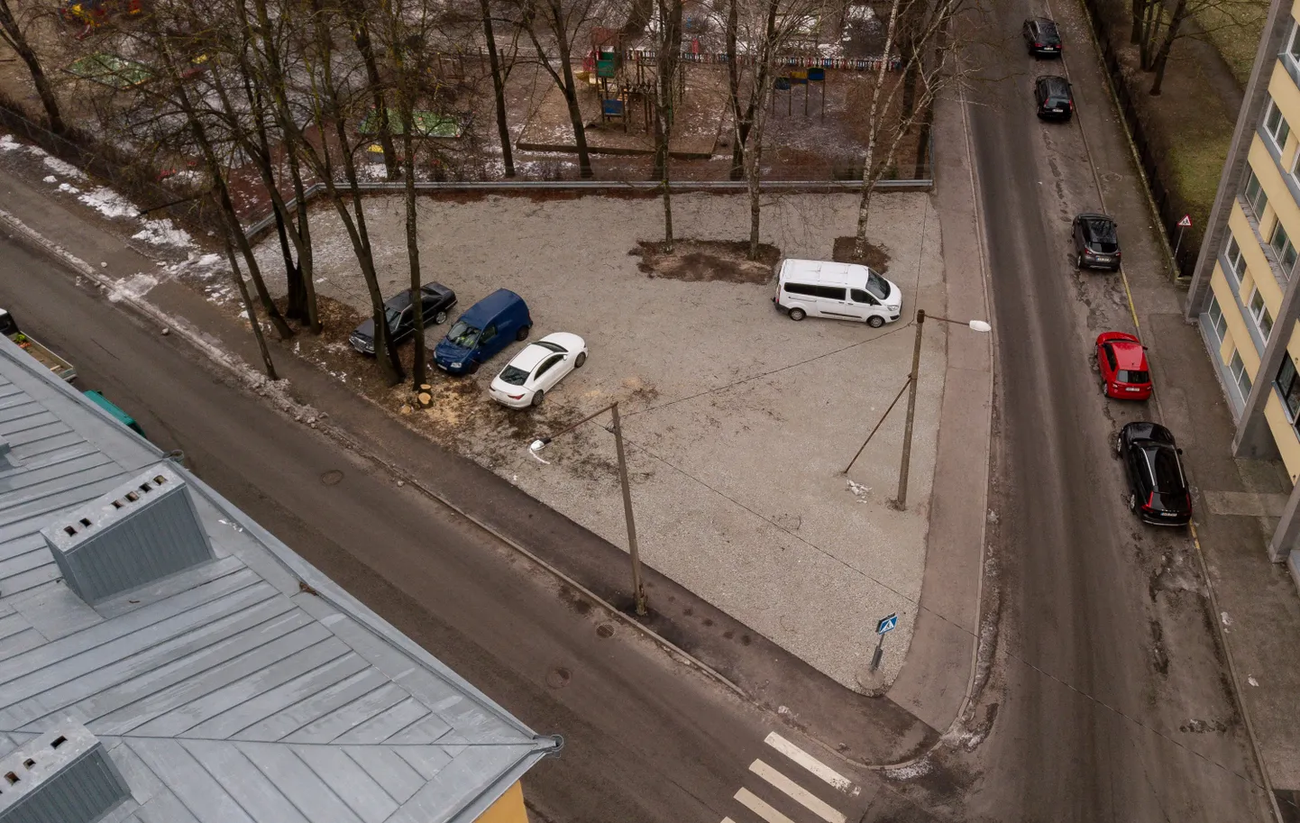 Hiljutisel haljasalal on mõned puud maha võetud ning maapind killustikuga kaetud.