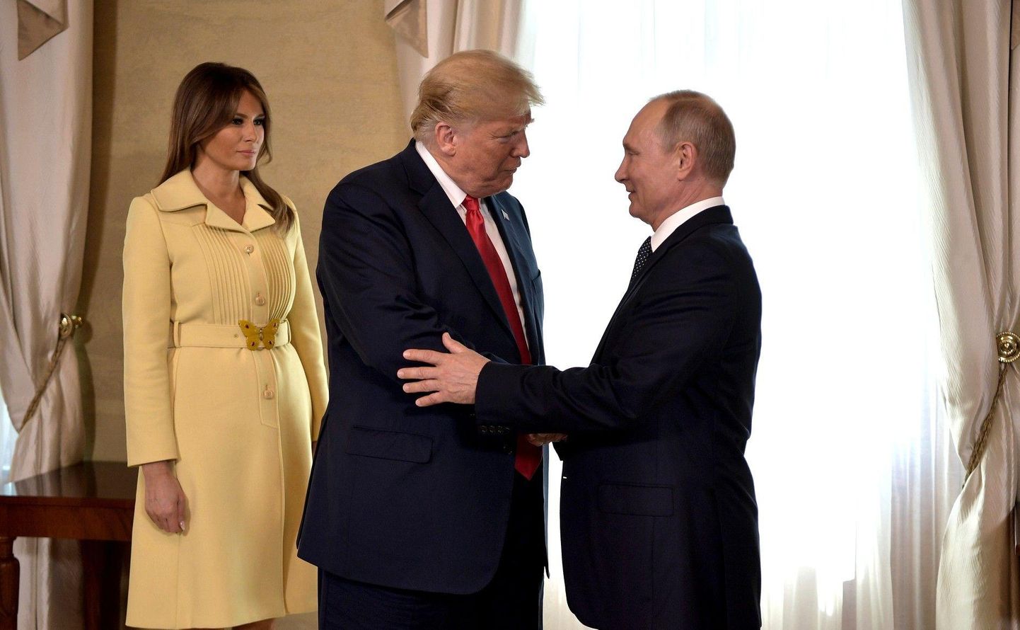 Donald Trump ja Vladimir Putin Helsingis enne kõnesid kätlemas, Trumpi selja taga seisab Melania Trump.<br />
 
