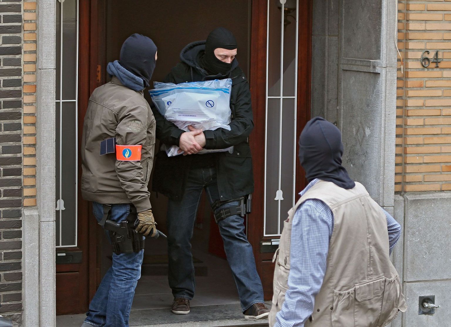 Maskides Belgia politseinikud kannavad tõendusmaterjali välja Brüsseli Anderlechti piirkonnas asuvast majast, mis otsiti eile läbi seoses päev varem toimunud pommirünnakutega.