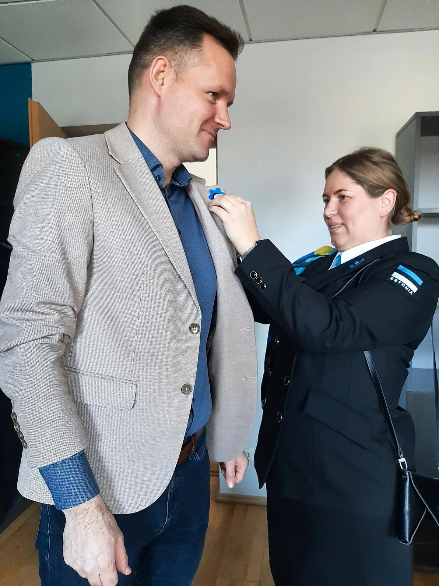 Naiskodukaitse Pärnumaa ringkonna esinaine Leiu Lepik aitas veteranikuu sümboolse sinililleõie kinnitada Pärnu abilinnapea Riido Villupi reväärile.