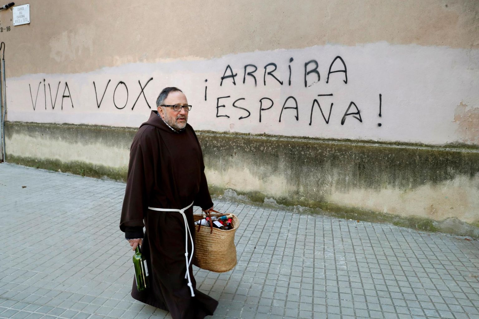 Frantsiskaani munk möödumas Barcelona kloostrist, mille seinale on vandaalid kritseldanud «Elagu Vox!» ja frankistide loosungi «¡Arriba España!» («Edasi Hispaania!»).