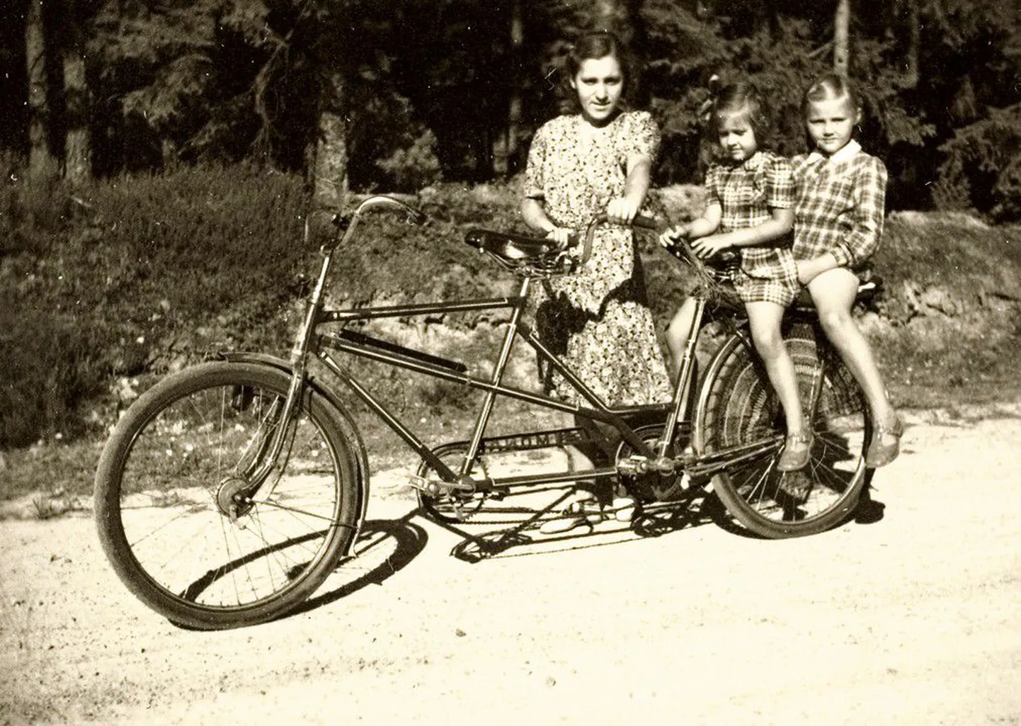 1945. aastal sõitsid ema ja lapsed tandemrattal mööda Rootsi väikekülade teid. Pilt jõudis Eesti Rahva Muuseumi kogusse 2006. aasta sügisel seoses väliseestlaste intervjueerimisega Rootsis, Ameerikas ja Kanadas.