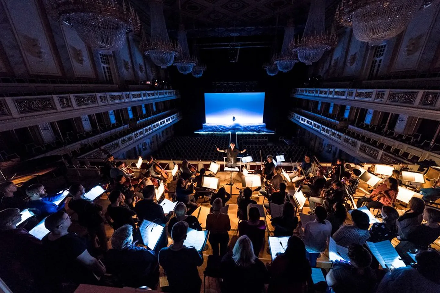 Arvo Pärdi ja Robert Wilsoni «Aadama passioon» etendus Berliini Konzerthausis, dirigent ja muusikajuht Tõnu Kaljuste seismas kontsertmaja orkestri ja Eesti Filharmoonia Kammerkoori ees.