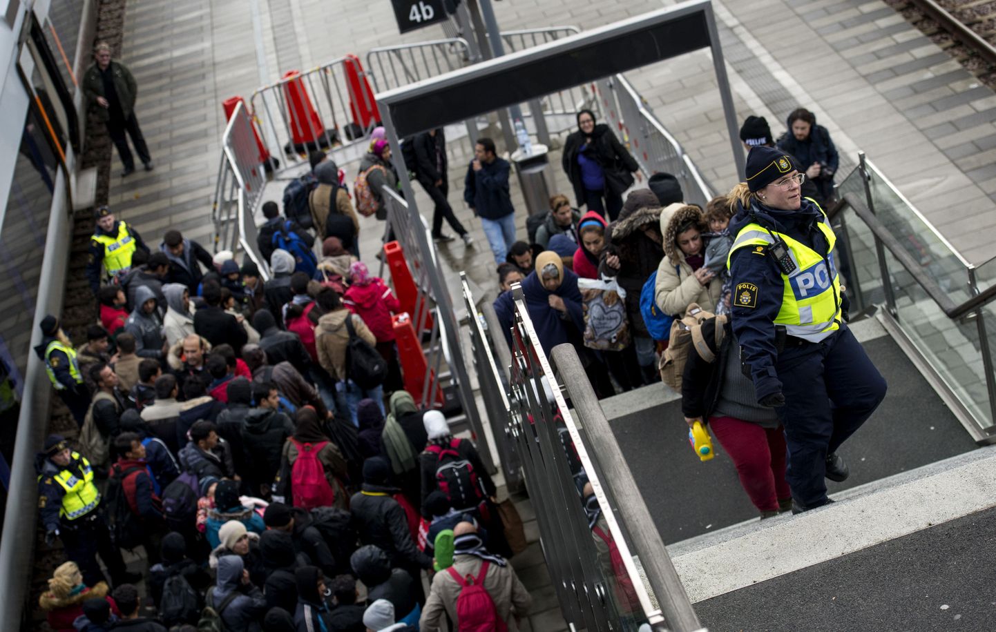 Rootsi politsei ohjab Taanist rongiga saabunud pagulasi Hyllie rongijaamas Malmö lähedal.