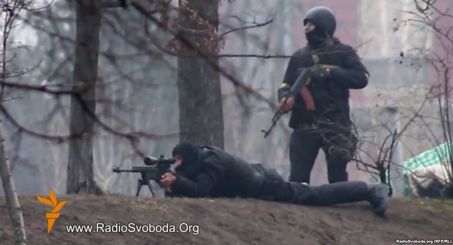 Kaader Raadio Vaba Euroopa filmitud videost, millel on näha meeleavaldajate pihta tulistavat snaiprit ja tema kõrval seisvat märulipolitseinikku. Kiiev, 20. veebruar.
