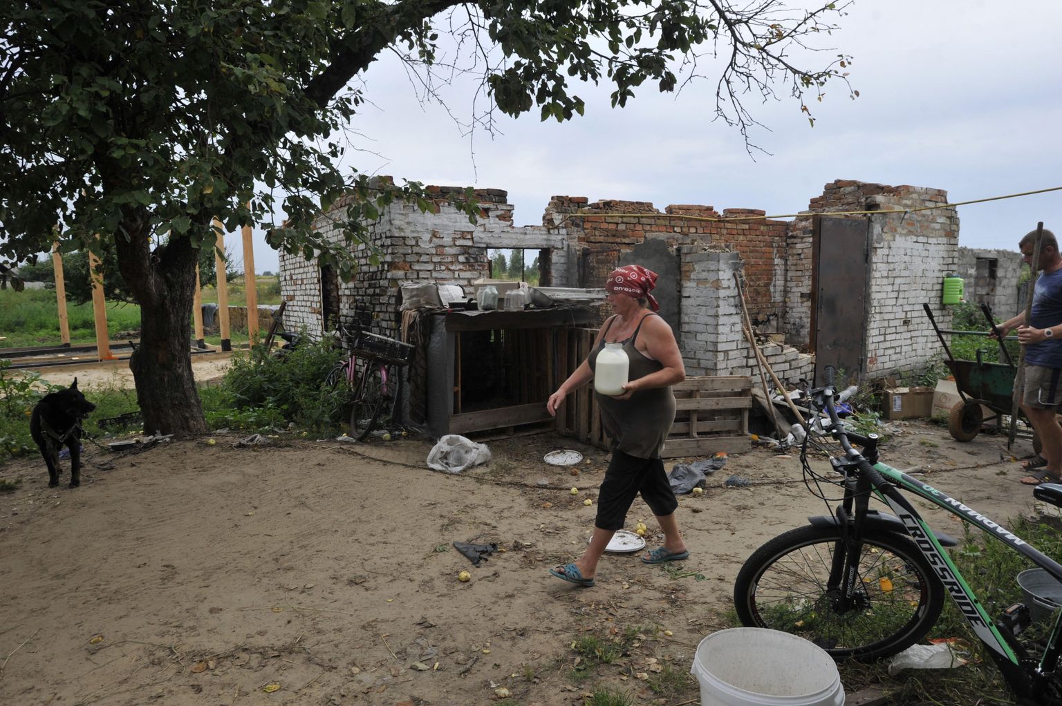 Sieviete pie savas izpostītās mājas Kijivas apgabalā.