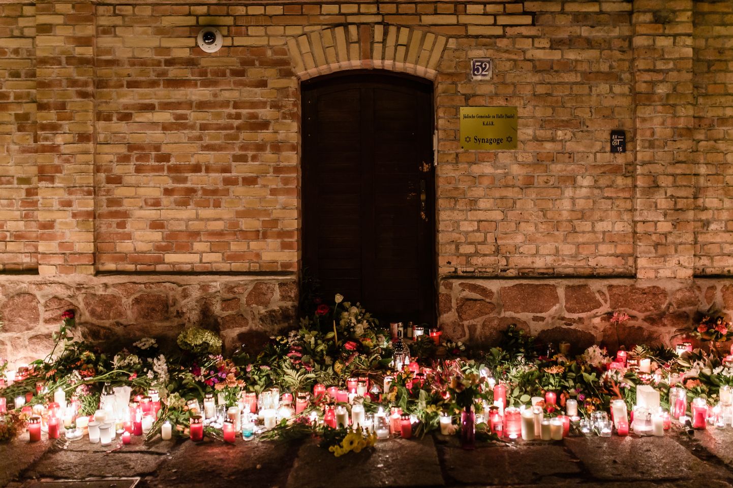 Halles iedzīvotāji pie sinagogas nolikuši ziedus un svecītes apšaudē nogalināto cilvēku piemiņai.
