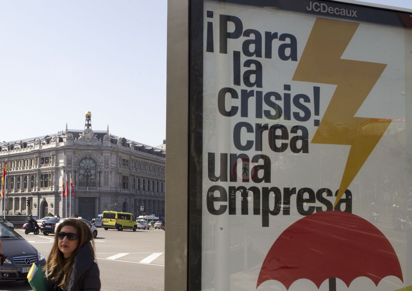 Naine Madriidis Hispaania keskpanga hoone ning posteri Peatage kriis taustal. Reitinguagentuur Moody's kärpis täna Hispaania võlareitingut pügala võrra, sest kardab, et panganduse restruktureerimise kulud lähevad valitsuse arvatust kaks korda kallimaks.