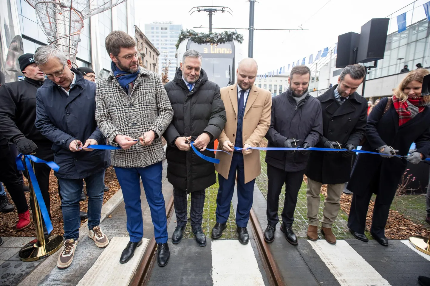 Mullu novembris aitasid Tallinna linnapeal Jevgeni Ossinovskil (vasakult teine) sadama trammitee avamisel linti läbi lõigata (vasakult) Tallinna Linnatranspordi ASi juhatuse esimees Kaido Padar, linnavolikogu esimees Toomas Kruusimägi, tollane taristuminister Vladimir Svet, abilinnapead Pärtel-Peeter Pere ja Kristjan Järvan ning Euroopa Komisjoni Eesti esinduse asejuht esinduse juhi ülesannetes Ave Schank-Lukas.