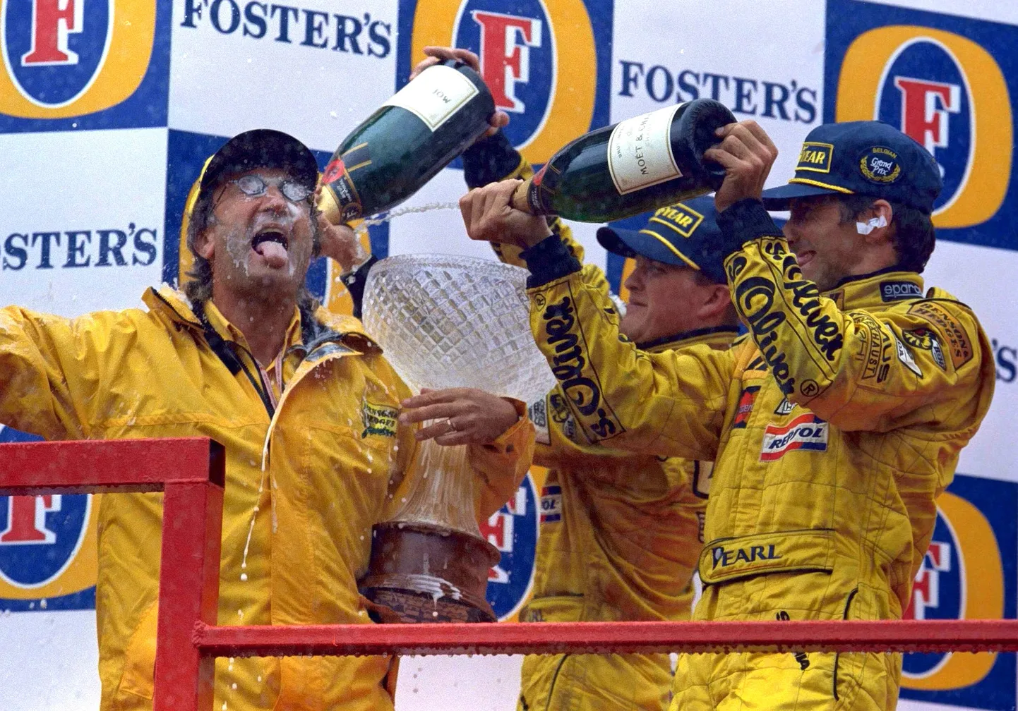 Eddie Jordani (vasakul) suur hetk 1998. aasta Belgia GP-l: tema tiimi sõitjad Damon Hill ja Ralf Schumacher on saanud kaksikvõidu ning kastavad Jordani šampanjadušiga üle.