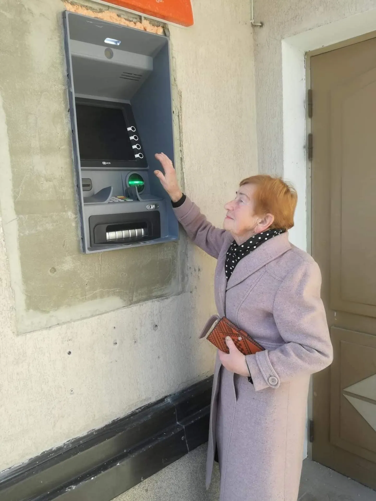 87-aastane Räpina elanik Olly Kodusaar ulatub vaevalt kõrgele paigaldatud automaadi nuppe vajutama.