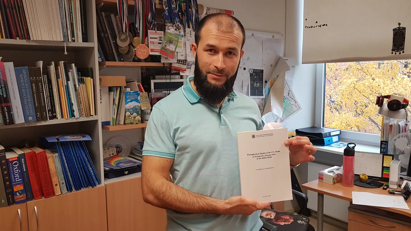 Казбулат Шогенов со своей докторской диссертацией, посвященной хранению углекислого газа.