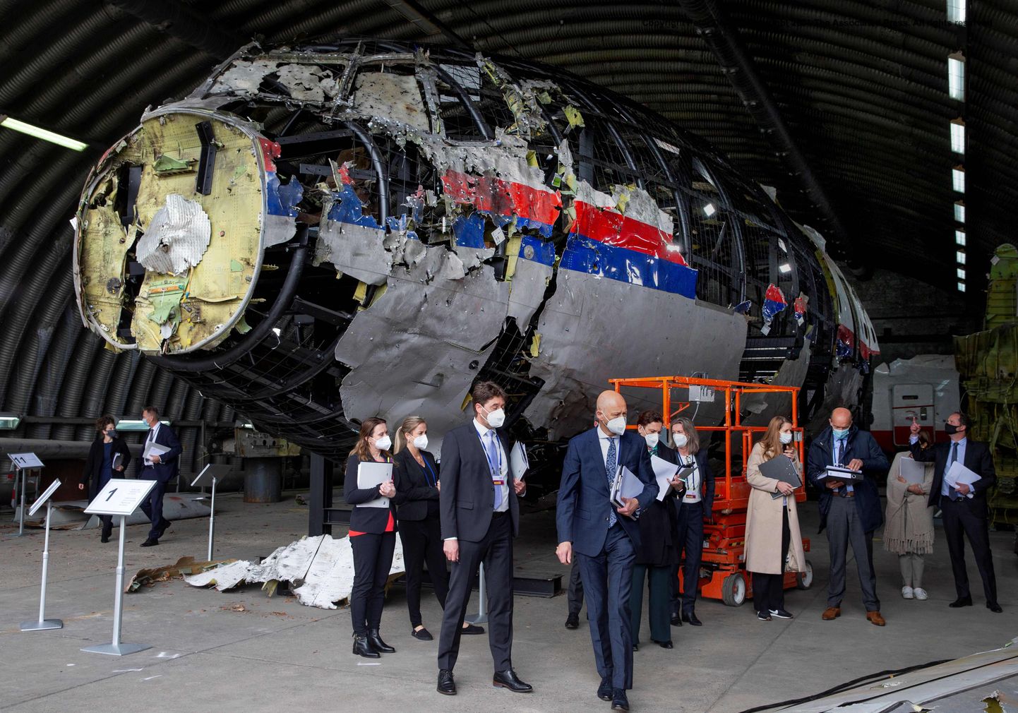 (FILES) In this file photo taken on May 26, 2021 presiding judge Hendrik Steenhuis (C), other trial judges and lawyers view the reconstructed wreckage of Malaysia Airlines Flight MH17, at the Gilze-Rijen military Airbase. - Dutch judges will on June 7, 2021 start hearing evidence against three Russian suspects and a Ukrainian in the downing of Malaysia Airlines flight MH17 over war-torn Ukraine in 2014. (Photo by Peter Dejong / POOL / AFP)