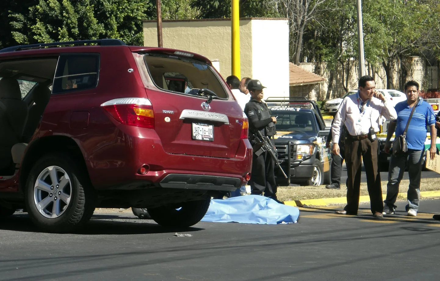 Mehhiko politseinikud seisavad Jalisco osariigi turismiministri Jose de Jesus Gallegose surnukeha juures.