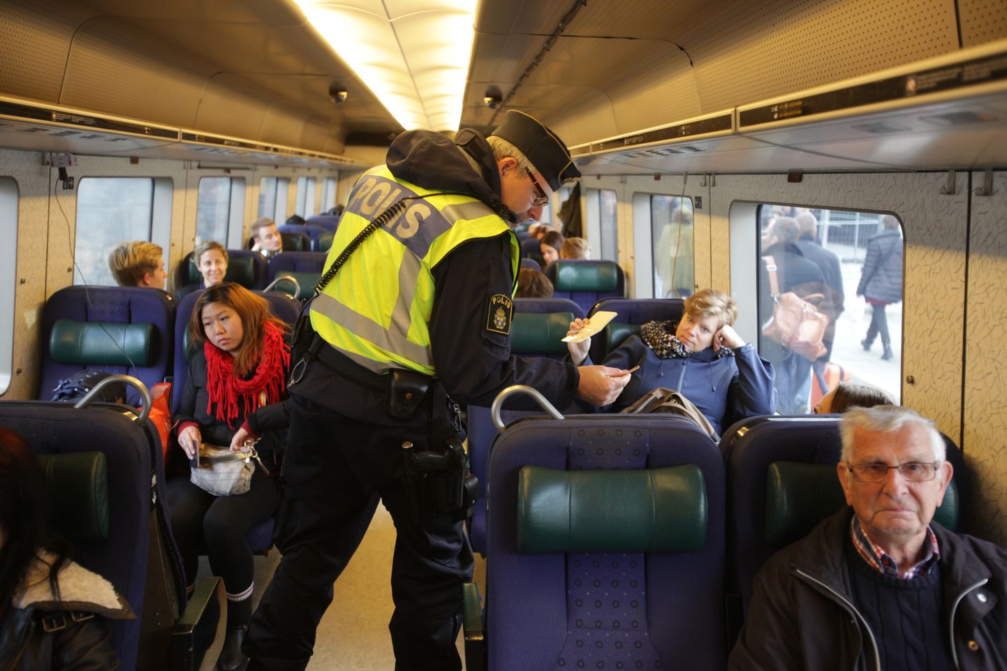 Rootsi politseinikud kontrollimas Taanist üle Öresundi silla riiki saabunud rongireisijate dokumente.