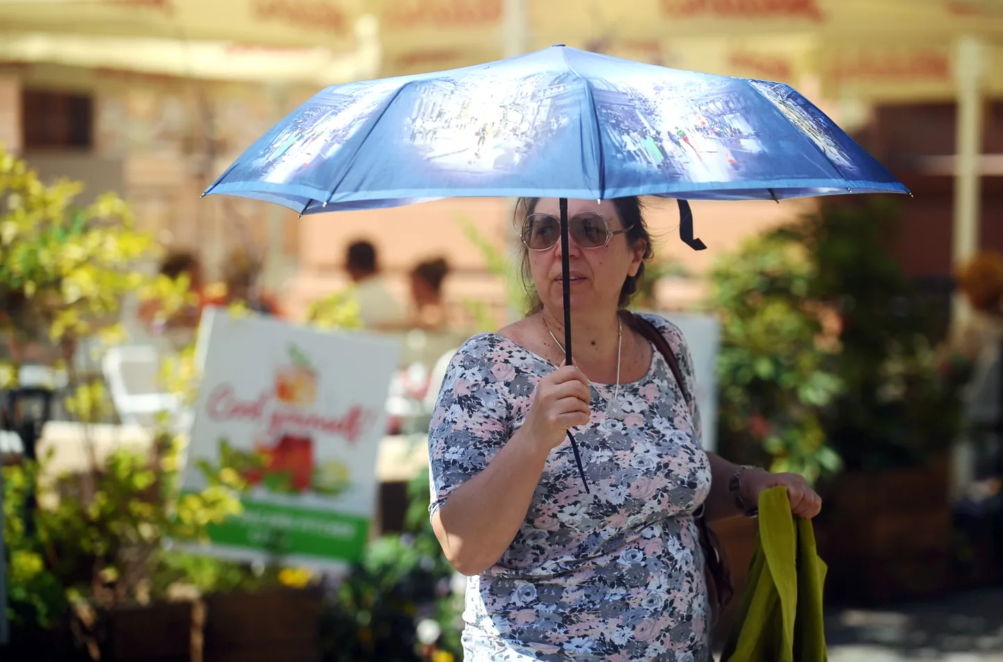 Sieviete ar lietussargu karstā vasaras dienā.