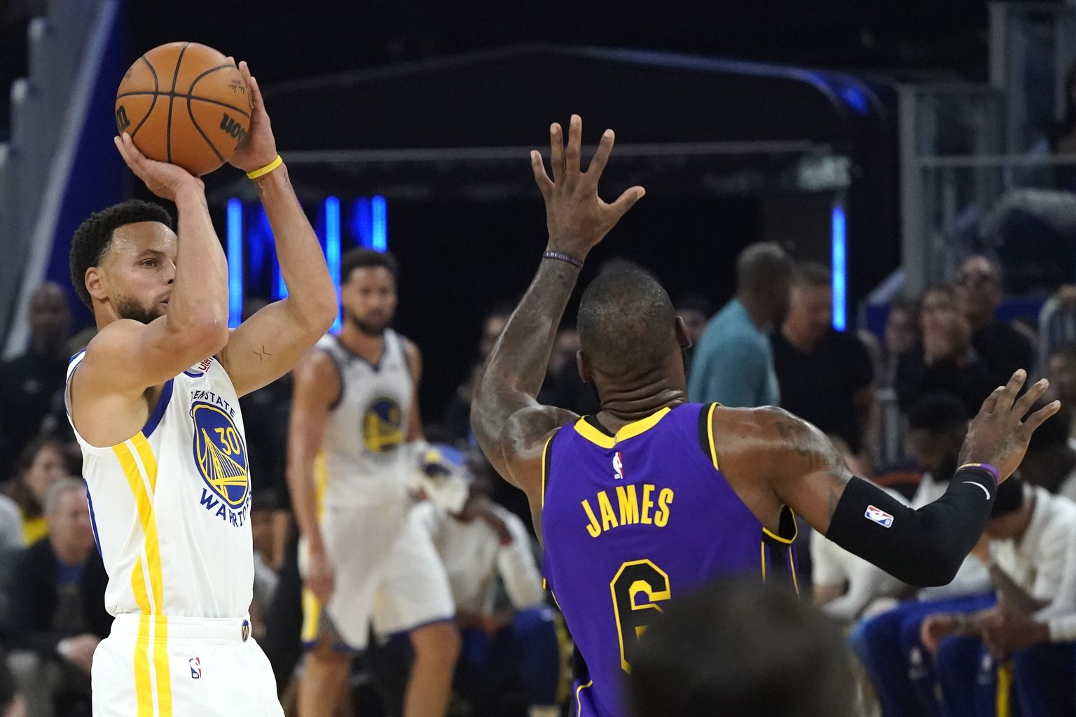 Golden State Warriorsi liider Stephen Curry (vasakul) saadab palli korvi suunas, Los Angeles Lakersi äss LeBron James ei jõua teda takistama.