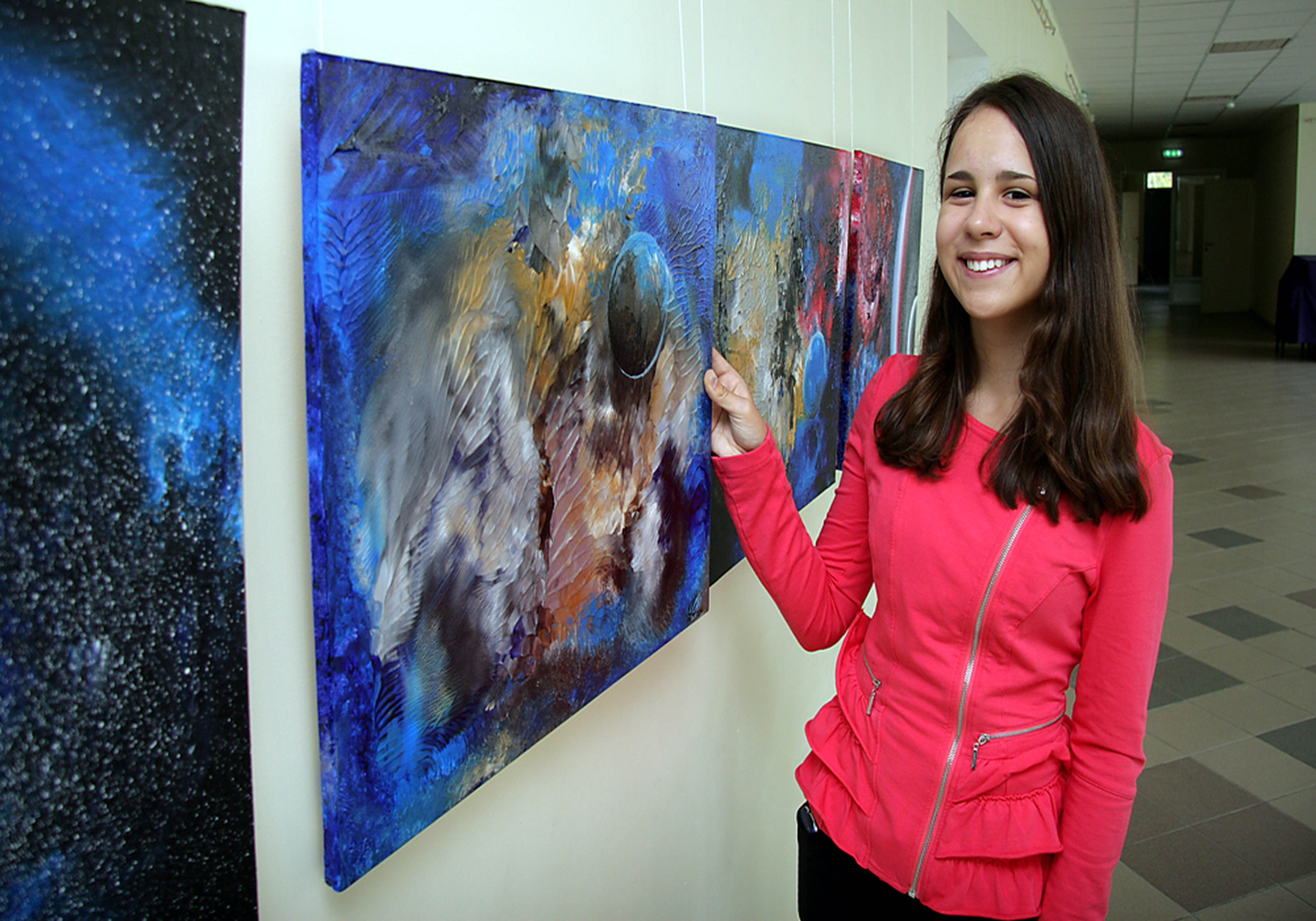 Милена Казначеева на фоне своих космических работ, выставленных в Кохтла-Ярвеской школе искусств.