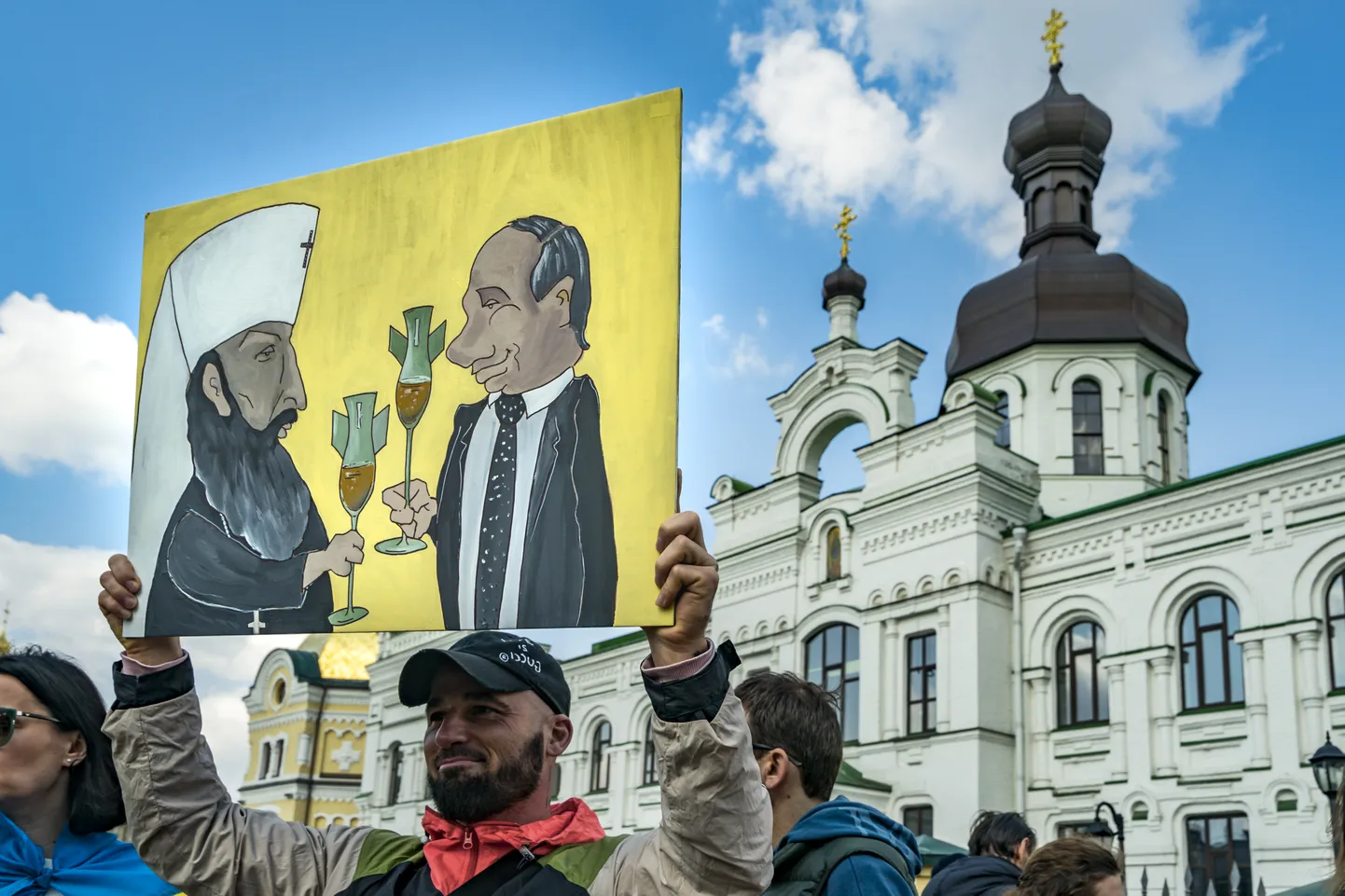 Meeleavaldaja plakatiga, millel on kujutatud Putin ja Moskva patriarh Kirill, 2023. aasta aprillis Ukrainas.