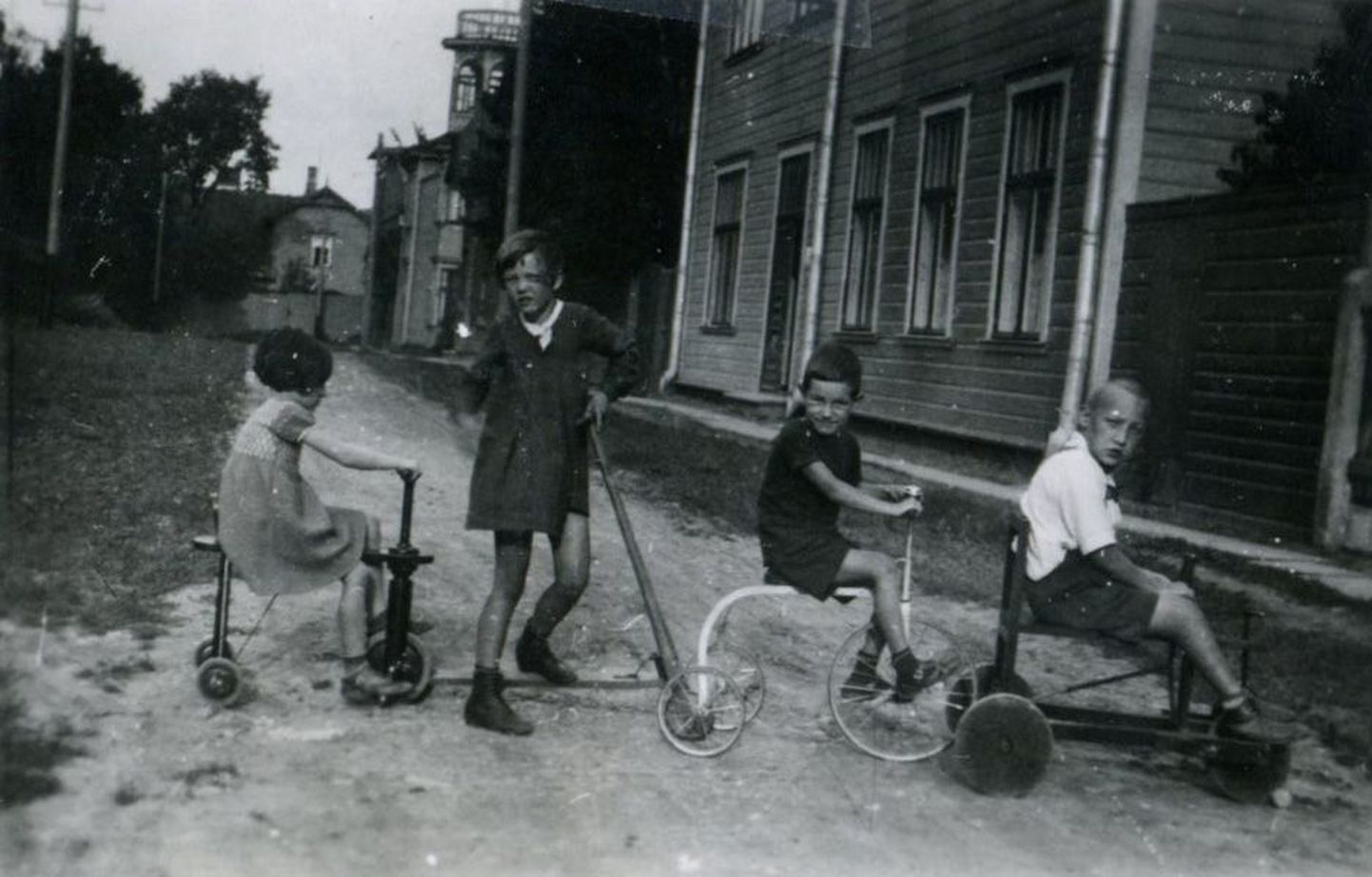 Vaade Päeva tänavast. Marja (keskel tõukerattaga) oma mängukaaslastega, sõbranna Putti ning vendade Meemo ja Oleviga Päeva 2 maja (jäi vasakule) ees.